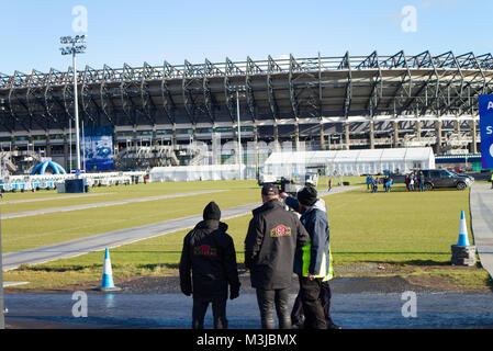 Edimburgo, Scozia, Regno Unito. Xi Febbraio, 2018. RBS 6 Nazioni - Scozia, Francia, Edimburgo, Scozia UK. Uno steward che mostra i fan francese i cancelli di ingresso al Murrayfield Stadium. Credito: Thomas Feige/Alamy Live News Foto Stock