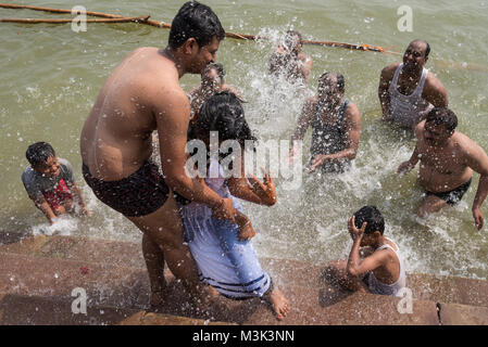 I membri della famiglia divertendosi nel Gange durante la Puja Chhath Festival, Varanasi (India). Foto Stock