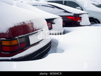 Frammenti di automobili parcheggiate ricoperte di neve Foto Stock