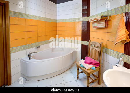 Interno della sala da bagno con vasca da bagno in tonalità di arancio Foto Stock