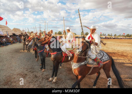 Cavalli e Cavalieri in carica con i cavalli e la ripresa di moschetti rievoca la guerra scene di attacco Tbourida Mzoudia in Marocco Foto Stock