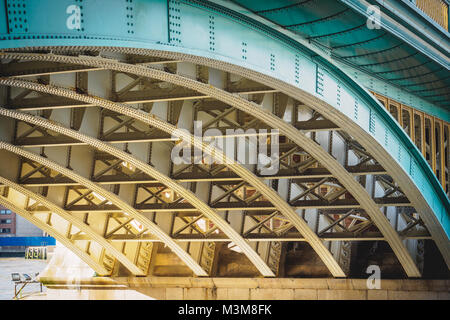 Travi di acciaio su un ponte ferroviario con le piastre di acciaio e i collegamenti rivettati. Formato orizzontale. Foto Stock