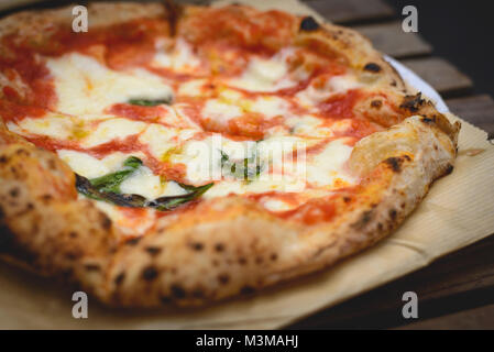 Vista ravvicinata di una margherita stile napoletano pizza con mozzarella di bufala, la salsa di pomodoro e basilico. Formato orizzontale. Foto Stock