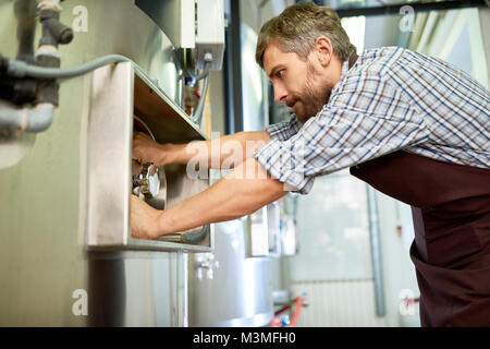 Occupato esperto tecnico di manutenzione riparazione Birreria Attrezzature Foto Stock