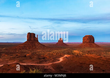 Famoso e visualizzazione classica di occidente e oriente Mitten e il Merrick Buttes in Monument Valley Navajo Tribal Park al crepuscolo, Arizona Foto Stock