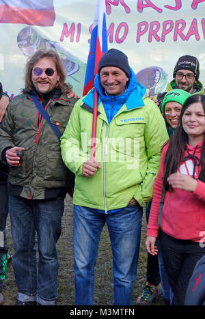 Borut Pahor Il presidente della Slovenia in posa con la bandiera nazionale per essere fotografato con ventole durante il campionato nel salto con gli sci per le donne. Ljubno ob Foto Stock