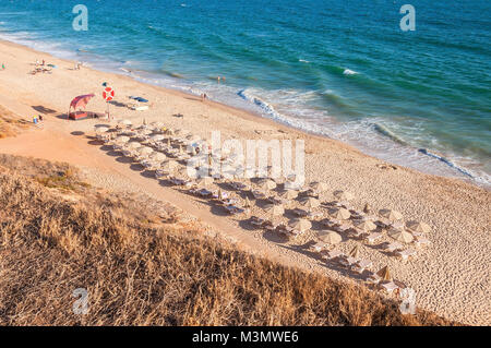 Lettini e ombrelloni sulla spiaggia di Falesia nel sole del pomeriggio, Algarve, PORTOGALLO Foto Stock