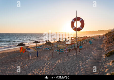 Lettini e ombrelloni sulla spiaggia di Falesia nel sole del pomeriggio, Algarve, PORTOGALLO Foto Stock