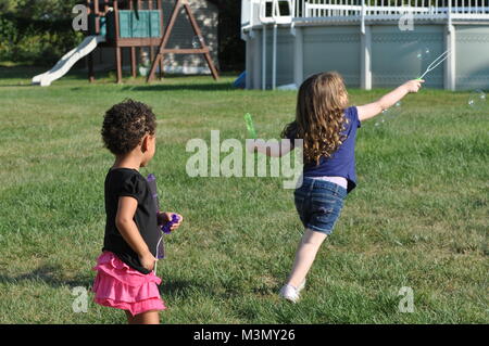 Due giovani ragazze a giocare con bolle Foto Stock