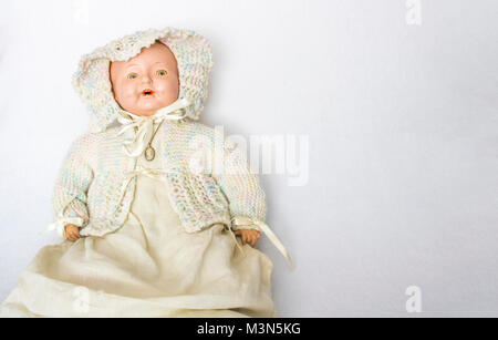 Antique Doll con maglia a mano del cofano e del maglione su sfondo bianco Foto Stock