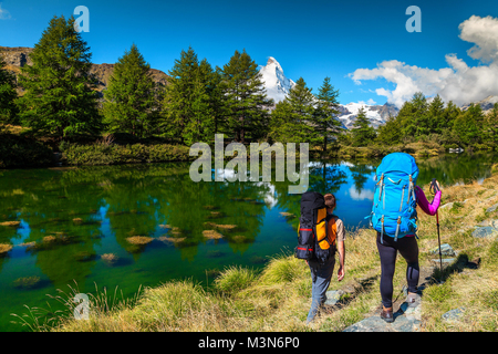 Gli escursionisti sportivo con zaino e attrezzature di montagna vicino alla celebre Grindjisee lago alpino nella regione del Canton Vallese, Zermatt, Svizzera, Europa Foto Stock