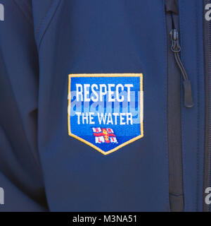 Una chiusura di un RNLI rispetto l'acqua una patch su un blu giacca in vello. Foto Stock