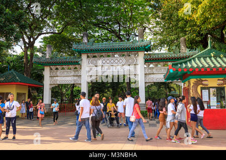 Manila, Filippine - Febbraio 4, 2018 : persone di passaggio di una strada nella parte anteriore del giardino cinese in Rizal Park, Filippine Iscrizione: Ingresso in Cina Foto Stock