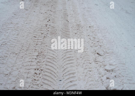 Close-up di sporco di neve in inverno nella città. Le tracce delle ruote delle auto del battistrada sulla neve. Foto Stock