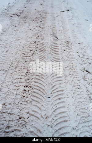 Close-up di sporco di neve in inverno nella città. Le tracce delle ruote delle auto del battistrada sulla neve. Foto Stock