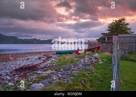 Sgranate vista serale guardando ad ovest sul Loch Carron verso Plockton con due spiaggiata derive da spiaggia a Ardaneaskan Foto Stock