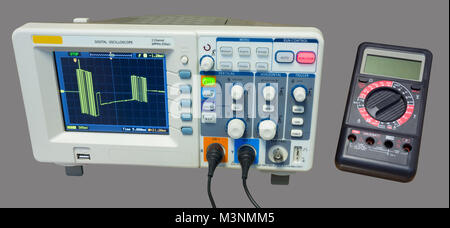 Oscilloscopio e multimetro. Misura dei dati i segnali di linea. Visualizzazione di industriali bus seriale il segnale sulla schermata del dispositivo. Isolato su sfondo grigio. Foto Stock