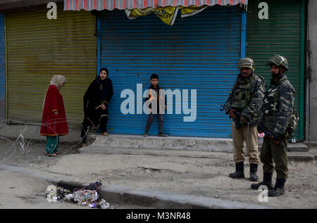 Srinagar, India. Xi Febbraio, 2018. Persone attraversano i fili spinati di attraversare la strada durante il coprifuoco a Srinagar Kashmir il 11 febbraio. Il coprifuoco è stato imposto in diffrerent parti della valle a thrawt proteste contro l'anniversario dell'esecuzione di Maqbool Bhat nel carcere indiano il 11 Feb 1984 Credit: Muzamil Mattoo/Pacific Press/Alamy Live News Foto Stock