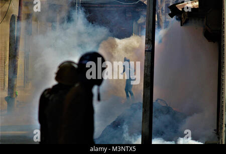 Poliziotto sparando gas lacrimogeni conchiglie, musulmana del Kashmir manifestanti, Baramulla, Kashmir India, Asia Foto Stock