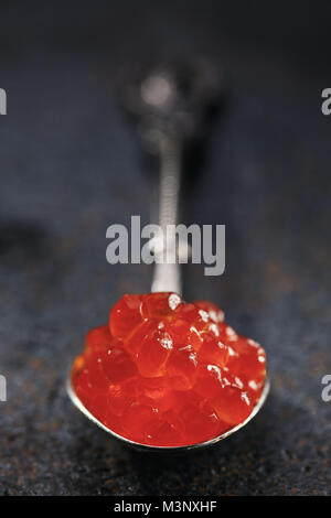 Cucchiaio di caviale rosso sul tavolo, close-up Foto Stock