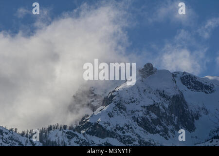 Nuvole che si eleva al di sopra del Snow capped cime delle Alpi austriache Foto Stock