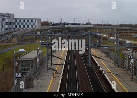 Una fotografia della Edinburgh Park stazione ferroviaria di Edimburgo, in Scozia, come un tram è in arrivo dall'aeroporto. Foto Stock