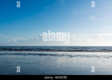 Appartamento spiaggia bagnata e mare calmo di sunny blue sky giorno