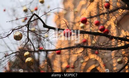 Strade completamente decorato per il Natale con il rosso e oro sfere. Albero di Natale in città. Casa illuminata con un sacco di luci. Anno nuovo tema. Foto Stock