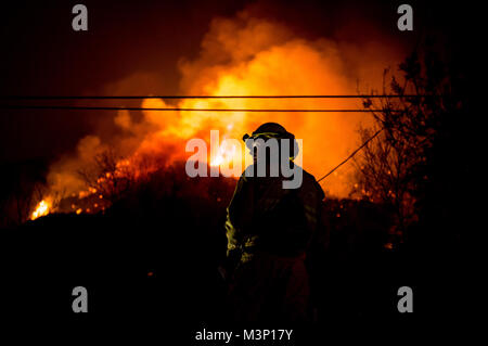 Chino Valley vigili del fuoco guarda le fiamme che sopraggiungono del Thomas il fuoco dal cantiere di una casa a Montecito, California, Dic 12, 2017. C-130Js dell'146Airlift Wing a Isole del Canale Air National Guard Base in Port Hueneme, eseguito il Modular Airborne sistema antincendio e gocciolata Fire Suppression sostanze chimiche sul fuoco il percorso per rallentare il suo avanzamento a sostegno dei vigili del fuoco sulla terra. (U.S. Air Force foto di J.M. Eddins Jr.) 171212-F-LW859-835 da AirmanMagazine Foto Stock