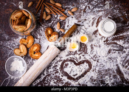 Vista dall'alto di gustosi biscotti fatti in casa e gli ingredienti sul piano del tavolo Foto Stock