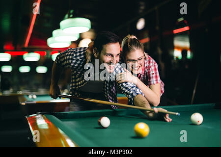 Coppia giovane giocare biliardo insieme in bar Foto Stock