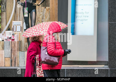 Preston, Lancashire. 12 feb 2018. Regno Unito: Meteo freddo, umido e nevoso per iniziare la giornata. Pioggia e neve le docce hanno spazzato attraverso il nord dell'Inghilterra per tutta la notte. Docce intenso continuare a coprire la regione inzuppando gli amanti dello shopping nel centro della citta'. Credito: MediaWorldImages/Alamy Live News Foto Stock