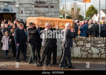 Forni, Irlanda. 12 Feb, 2018. I funerali del calciatore Liam Miller ha avuto luogo oggi a San Giovanni Battista, forni, County Cork, Irlanda. Un numero enorme di persone in lutto hanno assistito ai funerali, compresi molti calciatori di Miller del vecchio club, compresa la città di Cork, celtica e il Manchester United. La bara di Liam Miller è portato al suo ultimo luogo di riposo nel cimitero di San Giovanni Battista. Miller la moglie di Clare e la figlia Belle possono essere visti direttamente dietro la bara. Credito: Andy Gibson/Alamy Live News. Foto Stock