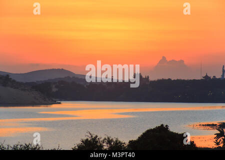 Alba sul lago. La mattina presto del paesaggio. la nebbia sull'acqua, foresta sagome e i raggi del sole nascente. Foto Stock