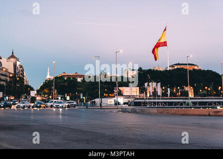 Madrid, Spagna - 1 Maggio 2017: Piazza di Columbus o Plaza del Colon di Madrid al tramonto con semafori e bandiera spagnola sventolare. Foto Stock