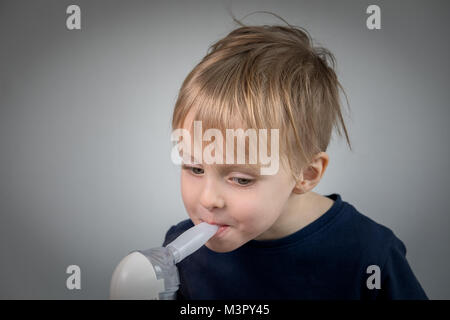 Little Boy takeing inalazione per didease respiratorio. Foto Stock