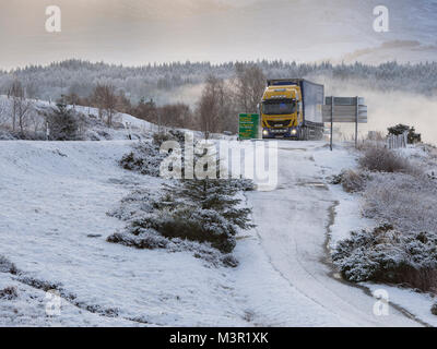 Autoarticolato viaggia sulla A82 in inverno. Come si vede dal commando Memorial vicino a Spean Bridge, Scotland, Regno Unito Foto Stock