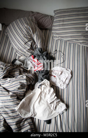 Vista aerea di un maschio di adolescenti letto disfatto con vestiti sparsi e caricabatterie per telefono cellulare Foto Stock