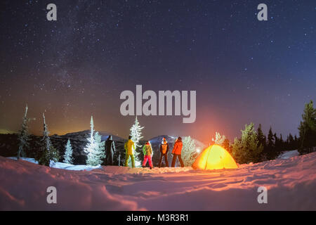 Viaggiare di notte inverno campeggio concetto con amici e tenda Foto Stock