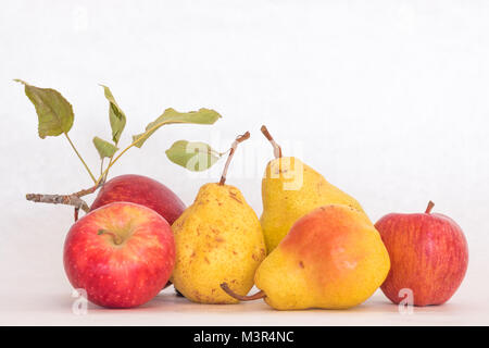 Tre Giallo maturo pelato pere e mele rosse, organico fresco bello studio shot con steli e foglie verdi Foto Stock