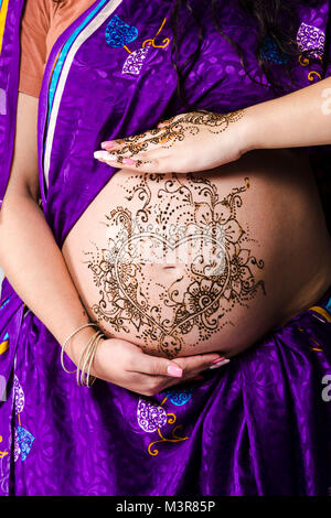 Una foto a colori di Henna Tattoo su una donna incinta del ventre. Foto Stock