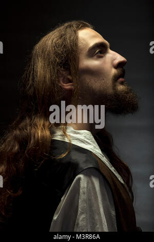 La personificazione di Gesù Cristo, l uomo con i capelli lunghi e la barba, pacificamente cercando fino alla luce Foto Stock