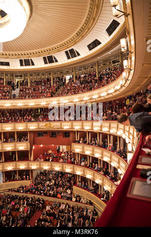 VIENNA, Austria - febbraio, 2018: interno dell'Opera di Stato di Vienna auditorium con il pubblico. Uomo che guarda verso il basso dalla parte superiore laterale tier sedi. Foto Stock