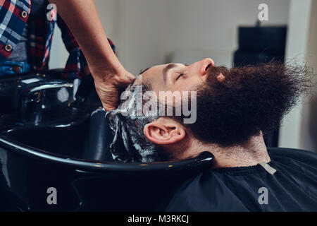Bel uomo barbuto in barberia. Foto Stock