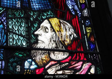 Il vetro macchiato le figure in una piccola chiesa da Harry clarke in Irlanda Foto Stock