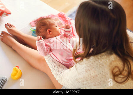 Giovane madre tenendo il suo bambino neonato. Mom lattante. La famiglia a casa da vicino Foto Stock