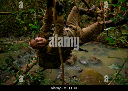 Tattiche speciali Officer Capt. Jack Ambridge utilizza un ponte di corde per attraversare un torrente durante una guerra nella giungla esercizio di formazione. Gli aviatori hanno imparato a rig e attraversare il ponte come parte della loro formazione. (U.S. Air Force foto/Master Sgt. Jeffrey Allen) 140617-F-CP197-2179 da AirmanMagazine Foto Stock