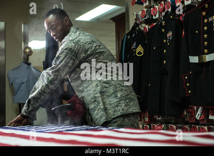 Il personale Sgt. DeAnthony Rosser, Dover affari mortuaria, operazioni di partenza specialista, vapori una bandiera americana alla Dover Air Force Base, Delaware. Avieri responsabile per la cura delle uniformi sul lavoro di lucidatura di metalli, decorazione preparazione e uniforme di tatto per ore al fine di dare alle famiglie dei caduti la migliore rappresentazione del militare degli Stati Uniti uniforme indossata dai loro cari. Avieri rimangono pronti a fornire onorato servizio per servizio caduti i membri nelle loro famiglie. (U.S. Air Force foto di/Staff Sgt. Vernon giovani Jr.) 160211-F-IO684-021 da AirmanMagazine Foto Stock