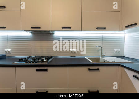 Nuovo incredibile contemporanea cucina in legno con forno moderno e lavello con rubinetto di acqua. Foto Stock