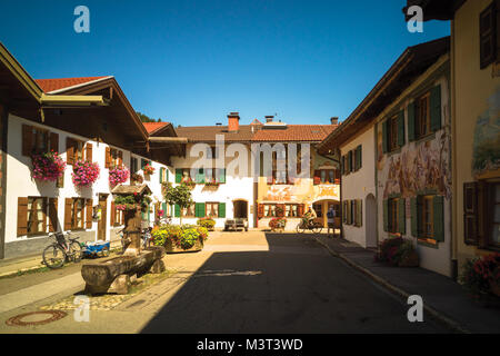 Tradizionale a bassa-aumento case decorate con pitture murali e piante in Mittenwald, Germania Foto Stock